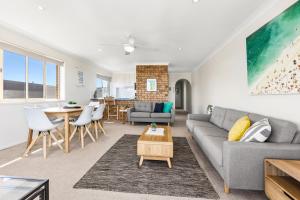 a living room with a couch and a table at Hungerford Beach Apartment by Kingscliff Accommodation in Kingscliff