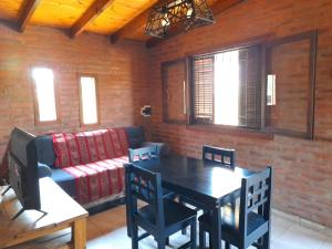a living room with a table and a couch at Cabaña EL ZORZAL de Villa del Dique in Villa del Dique