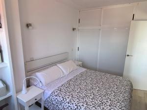 ラスパルマス・デ・グランカナリアにあるLos Gueldesの白い小さなベッドルーム(ベッド1台、テーブル付)