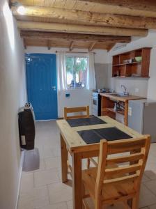 a kitchen with a wooden table and a blue door at Barrio Arrayanes in El Bolsón