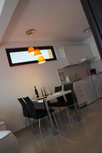 comedor con mesa y sillas en la cocina en Apartments Adriatico, en Herceg-Novi