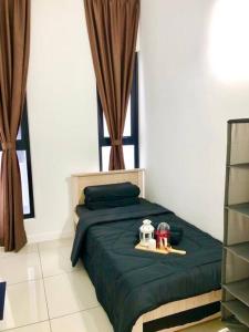 a bedroom with a green bed with toys on it at Cozy Mayfair Homestay in Puchong