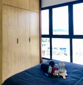een slaapkamer met een bed met een blauwe sprei en apparatuur erop bij Cozy Mayfair Homestay in Puchong