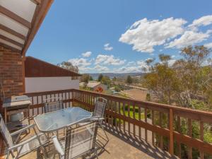 a balcony with a table and chairs and a grill at Snowy Saga 1 46 Gippsland Street in Jindabyne +1 photo