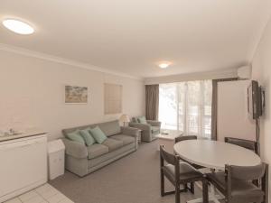 una sala de estar con un sofá y una mesa en Horizons 505/10 Kosciuszko Road, en Jindabyne
