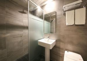 ein Badezimmer mit einem Waschbecken, einem Spiegel und einem WC in der Unterkunft West In Hotel Yeosu in Yeosu