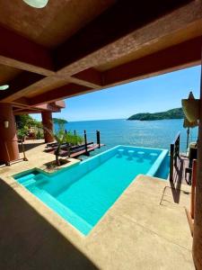 a swimming pool with a view of the water at El Nido Casa 4 - Paradise on the Bay in Zihuatanejo