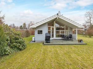 a small white cottage with a deck and a table at 6 person holiday home in Væggerløse-By Traum in Bøtø By