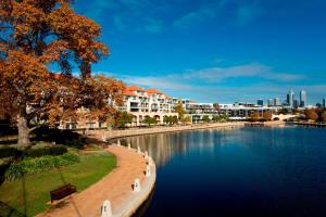 パースにあるEast Perth Suites Hotelの建物を背景に流れる川の景色