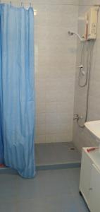 un bagno con doccia e tenda da doccia blu di SPANISH VILLA Lonos ROMBLON a Agnay