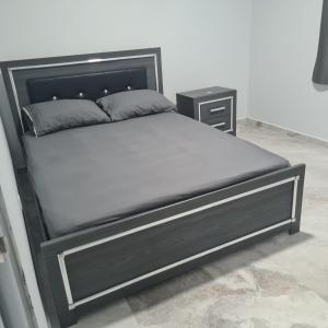 uma cama com uma cama preta e uma mesa de cabeceira em New Modern Apartment em Willemstad