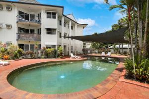 a pool with a pool table in front of a house at Citysider Cairns Holiday Apartments in Cairns