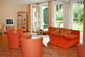 a living room with an orange couch and a table at Cottages in fir park, fir in Tanne