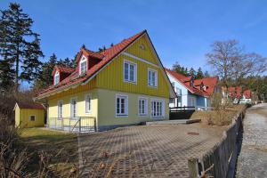 a yellow and green house with a red roof at Ferienhäuser im Tannenpark, Tanne in Tanne