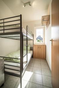 a bedroom with two bunk beds and a window at Ferienhaus an der Wiese, Tanne in Tanne
