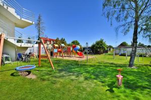 une aire de jeux avec un tas d'équipements de jeux dans une cour dans l'établissement Cottage in Siano ty near Sandy Beach, à Sianożęty