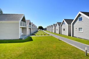 une rangée de maisons dans une rue herbeuse dans l'établissement Cottage in Siano ty near Sandy Beach, à Sianożęty
