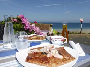 LandeleauにあるEstate in Landeleau near Aulne Riverの食べ物の皿2枚と水の入ったコップが置かれたテーブル +27枚の写真