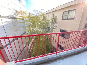 a balcony with a red railing in front of a building at Yoyogi Apartment 2-401 in Tokyo