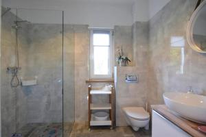 een badkamer met douche, wastafel en toilet bij Comfortable holiday home with a private garden in Debina +26 foto's