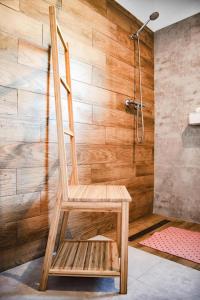 una silla de madera sentada frente a una ducha en Holiday Home in Debina near Baltic Sea, en Debina