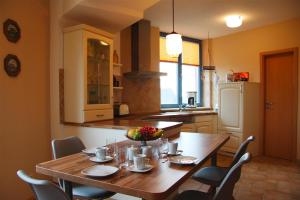 a kitchen with a wooden table and chairs in it at Holiday flat im Wasserturm Güstrow - DMS01100b-P in Güstrow