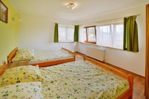 two beds in a room with green curtains at Semi-detached houses, Sarbinowo in Sarbinowo