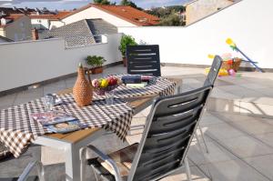 a table and chairs on a balcony with a table at Apartments Crobeg in Rab