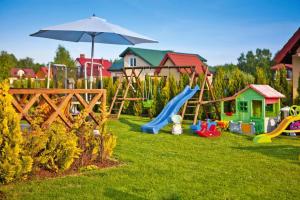 a playground with a slide and an umbrella at Semi-detached houses, Rowy in Rowy