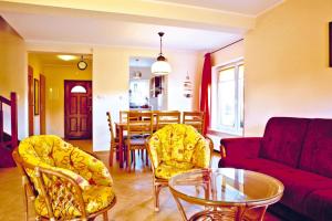 a living room with a couch and chairs and a table at Half of holiday home, terrace, playground in Rowy