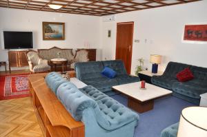 a living room with blue couches and a tv at Apartments Crobeg in Rab