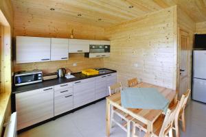 a kitchen with a table and a wooden wall at Holiday resort, Sarbinowo in Sarbinowo