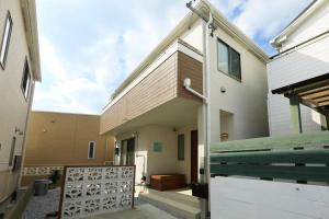 una casa con una valla de madera junto a un edificio en SHIOYA STAY en Okinawa City
