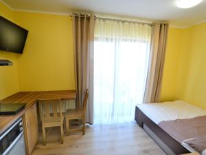 Schlafzimmer mit einem Bett, einem Schreibtisch und einem Fenster in der Unterkunft Holiday resort, Sarbinowo in Sarbinowo