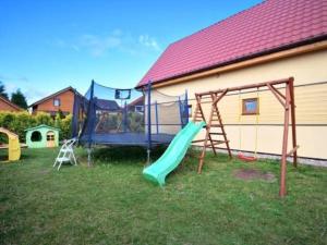 einen Spielplatz mit Rutsche und Schaukel in der Unterkunft Holiday resort, Sarbinowo in Sarbinowo