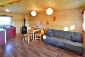 a living room with a couch and a table and a kitchen at Comfortable bungalows with a fireplace and terrace Jaroslawiec in Jarosławiec