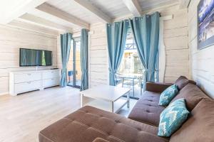 a living room with a couch and a tv at Terraced Houses, Grzybowo in Grzybowo