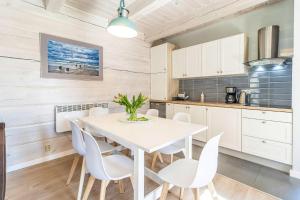 a kitchen and dining room with a table and chairs at Terraced Houses, Grzybowo in Grzybowo