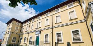 a large yellow building with white windows on a street at Hotel Il Duca Del Montefeltro in Pennabilli +13 photos