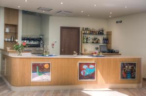 a lobby with a counter with paintings on it at Hotel Il Duca Del Montefeltro in Pennabilli