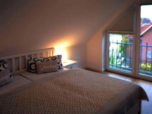 een slaapkamer met een bed en een groot raam bij Home port holiday home, Dornum in Dornumersiel