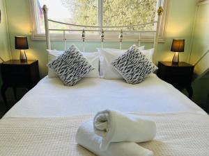 a white bed with pillows and a towel on it at Serenity in Healesville