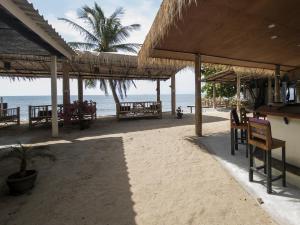 a beach with tables and chairs and the ocean at Isara Lanta Beach Resort in Ko Lanta
