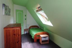 a green bedroom with a bed and a window at Cottage, Langoat in Langoat