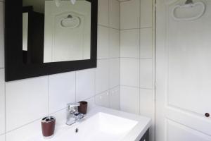 a white bathroom with a sink and a mirror at Holiday Home near Rosa Granite Coast Beaches in Langoat +16 photos