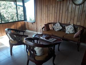 a living room with a couch and a table and chairs at Wood cabin in Kandy
