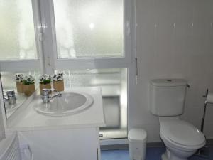 a white bathroom with a toilet and a sink at Studio, Audierne in Audierne