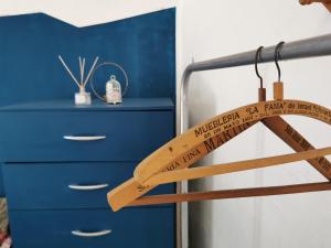a wooden bat hanging from a rail next to a blue dresser at Doña Isabel 1 in Gualeguay