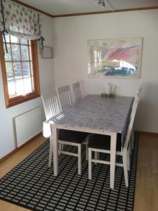 uma mesa de jantar e cadeiras num quarto em Idyllic bungalow close to sea and forest em Ronneby