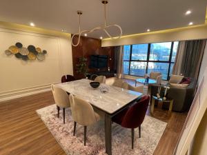 a dining room and living room with a table and chairs at Family Luxury apartment at Milsa Nasr City , Building 27 in Cairo
